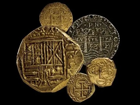 A collection of gold and silver ancient coins on a black background.